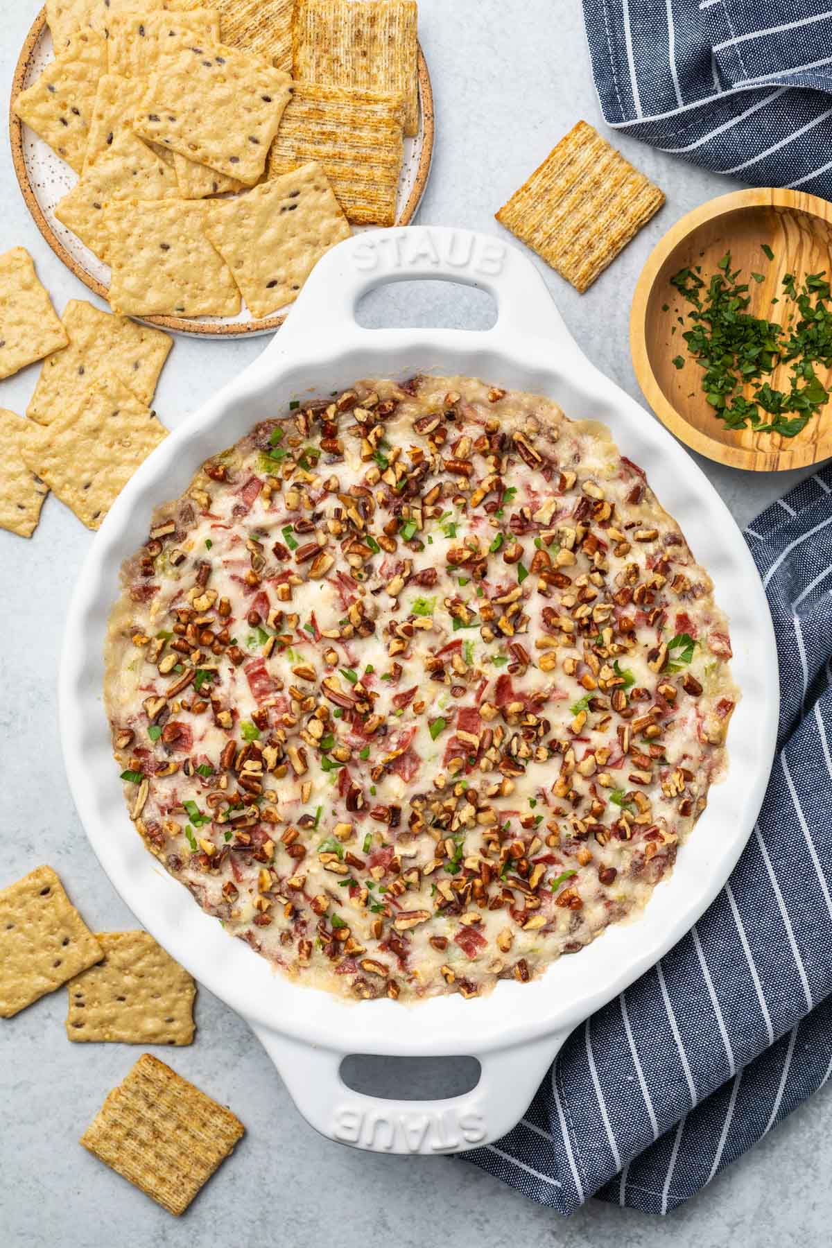 overhead image of chipped beef dip in a white pie plate surrounded by crackers
