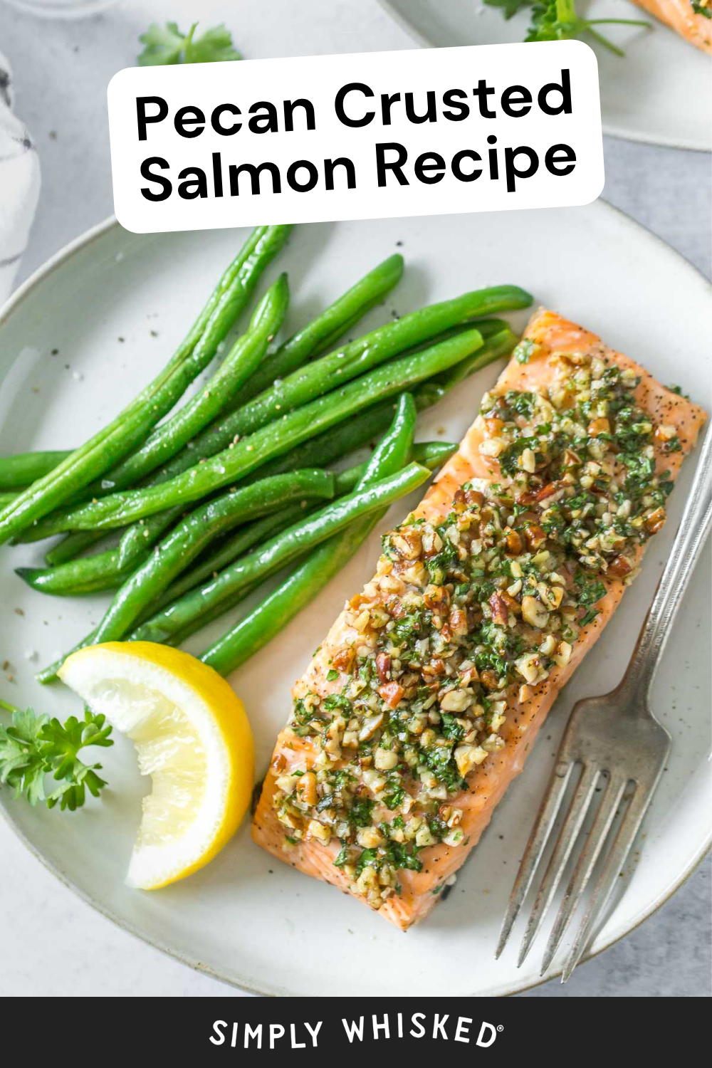 A plate with pecan crusted salmon, green beans, a lemon wedge, and a fork. Text on the image reads Pecan Crusted Salmon Recipe. The site name Simply Whisked is visible at the bottom.