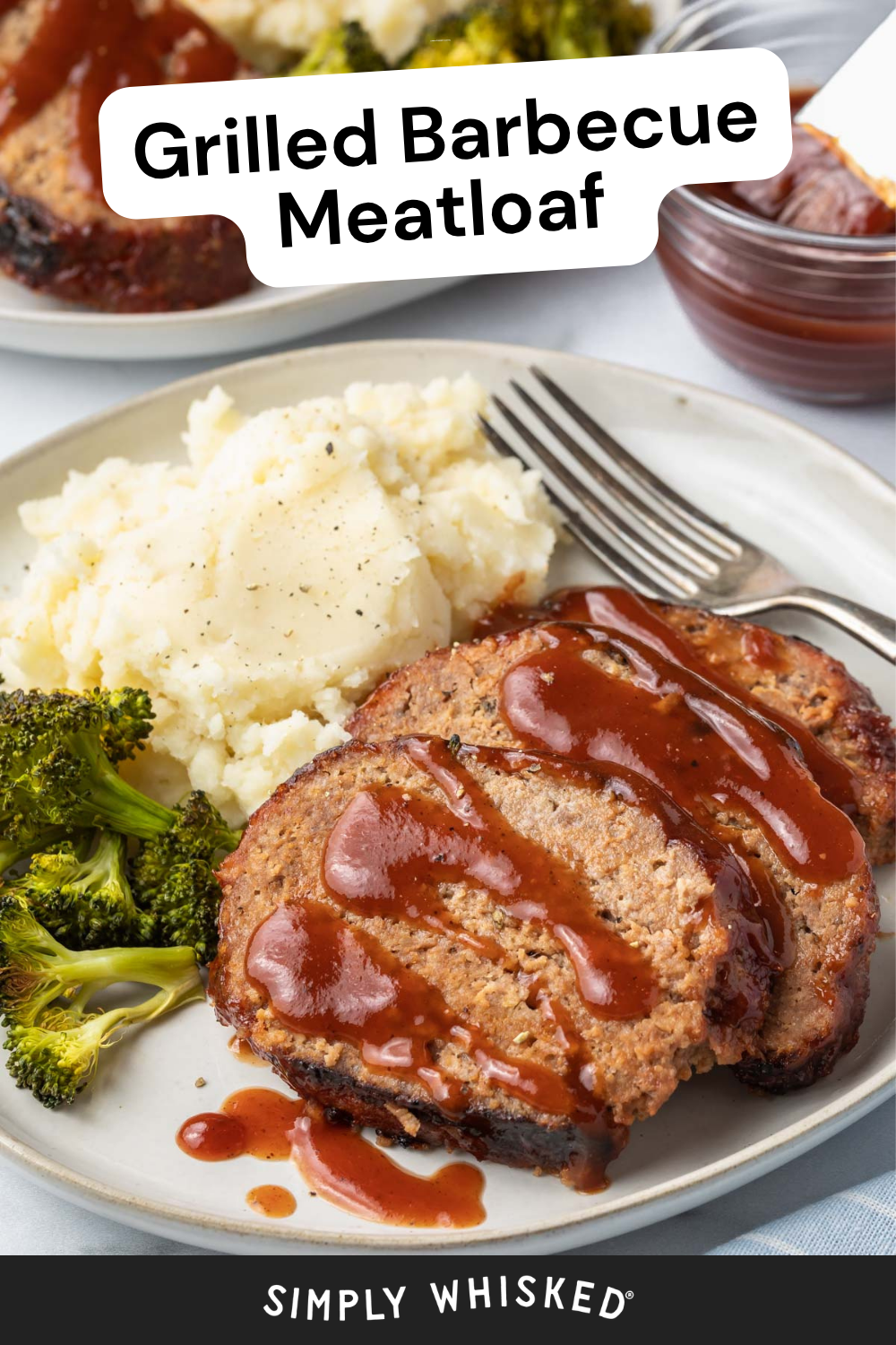 Two slices of grilled barbecue meatloaf topped with savory sauce, served alongside creamy mashed potatoes and fresh broccoli on a plate. A fork, napkin, and small bowl of barbecue sauce are nearby to complete the meal. Text reads Grilled Barbecue Meatloaf.