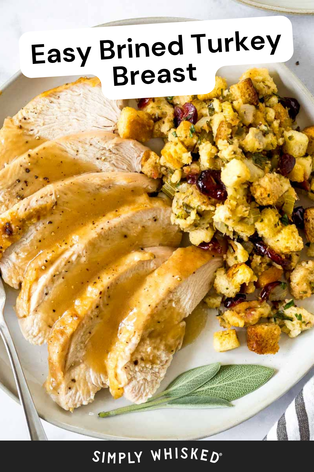 Sliced brined turkey breast with gravy, served alongside stuffing with cranberries and celery on a white plate. A fork and striped napkin are partially visible. Text reads: Easy Brined Turkey Breast. SIMPLY WHISKED.
