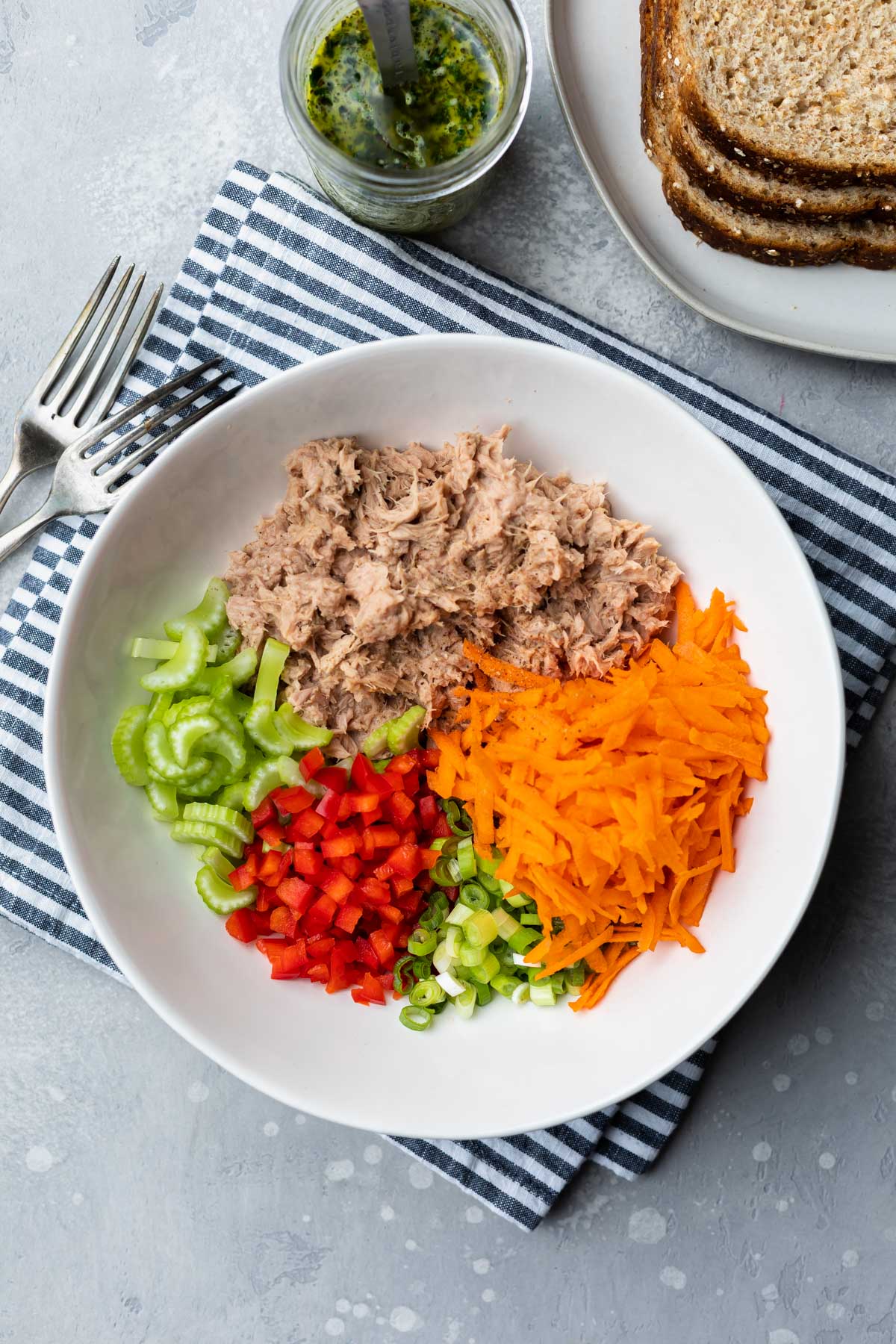 Tuna, carrots, green onion, red bell pepper and celery in a bowl. 