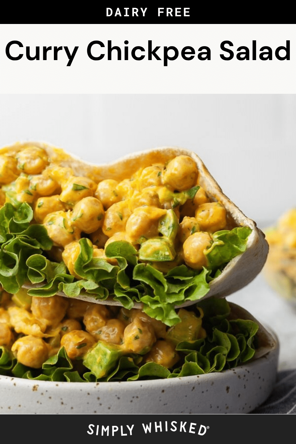 Close-up of pita pockets filled with lettuce and a creamy curry chickpea salad, stacked on top of each other. The text above reads Curry Chickpea Salad — a flavorful, dairy-free twist featuring our signature curry chickpea salad filling.