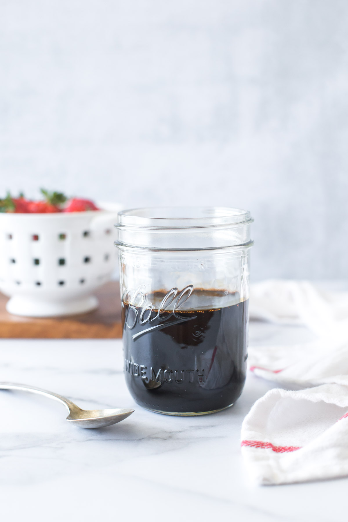 balsamic reduction (balsamic glaze) in a mason jar with a spoon to the side
