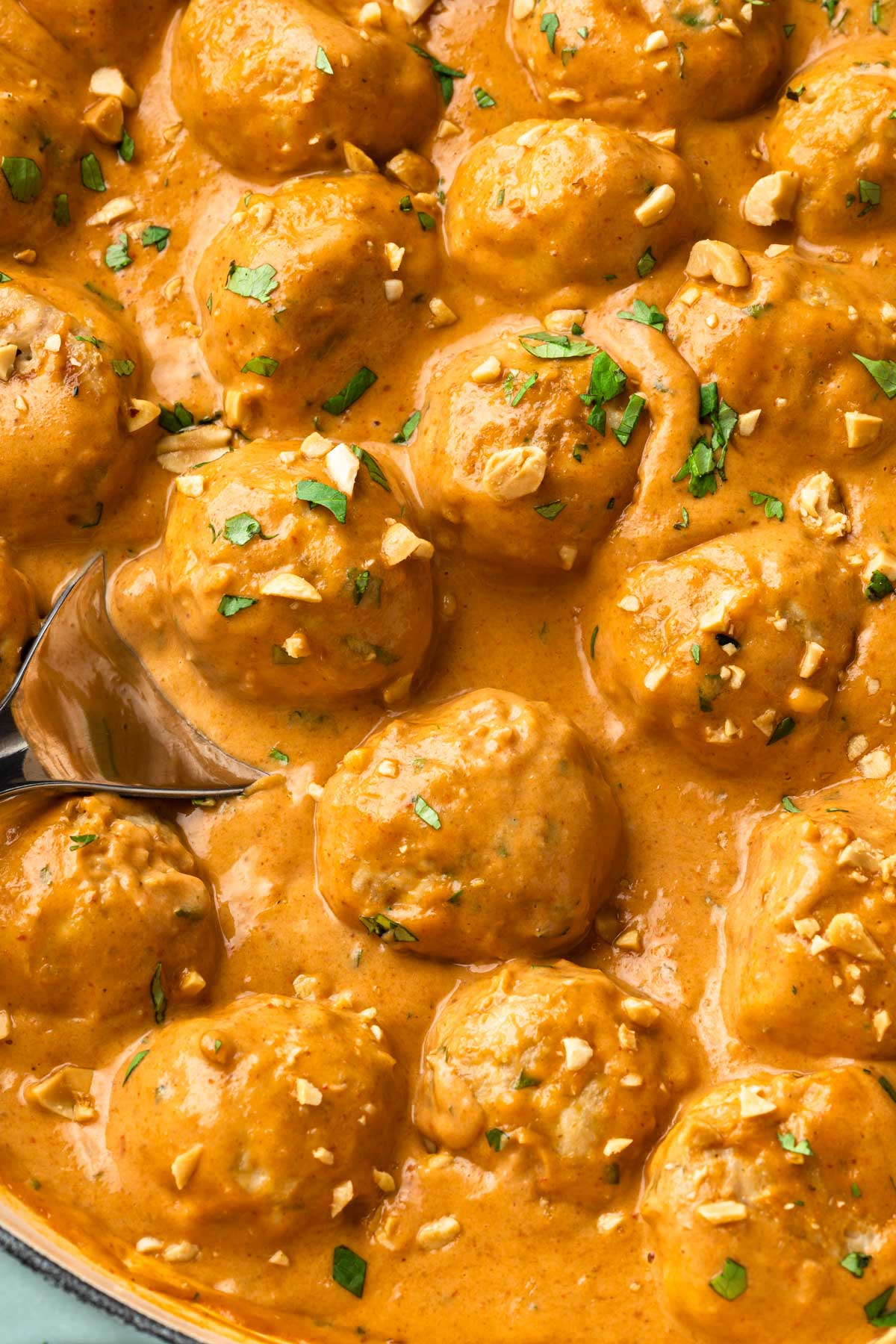 Close up of chicken meatballs in a peanut sauce. 