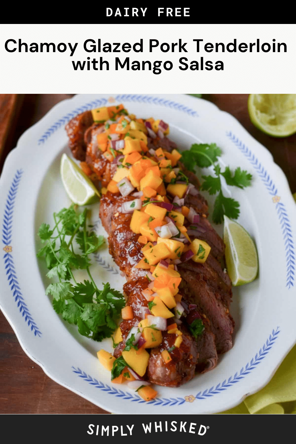 Chamoy glazed pork tenderloin, sliced and topped with colorful mango salsa, garnished with cilantro and lime wedges, served on a white platter.