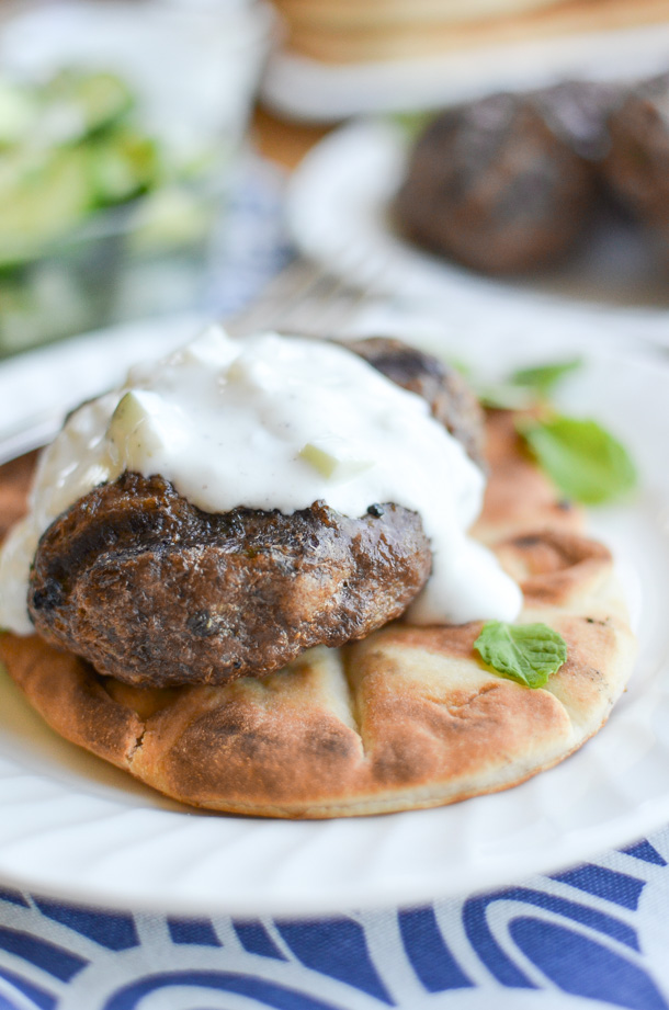 grilled beef kofta on flatbread topped with cucumber sauce and fresh mint