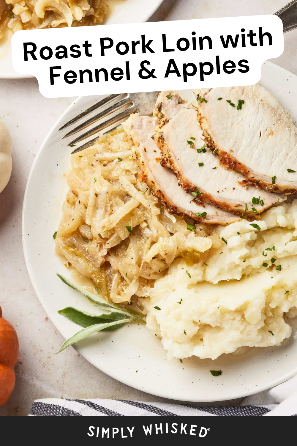 A plate with roast pork loin slices, caramelized fennel and apples, and mashed potatoes, garnished with herbs. A fork and sage leaf rest on the plate beside the flavorful roast pork loin with fennel, with part of another plate visible in the background.