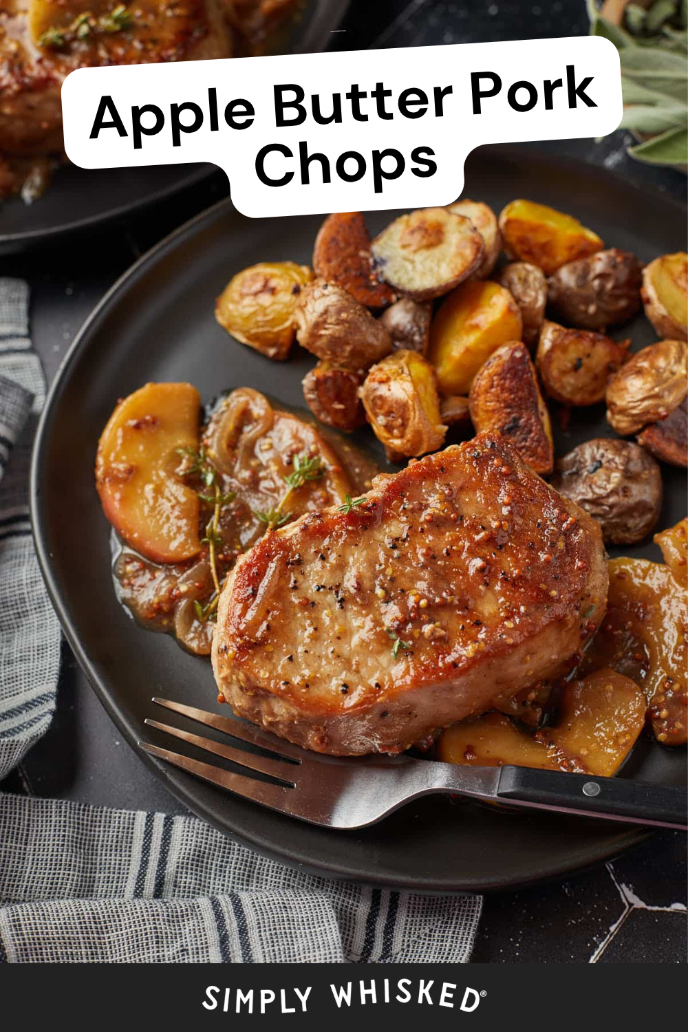 A plate with a seared pork chop, roasted potatoes, apple slices, and herbs showcases the delicious appeal of apple butter pork chops. A fork and knife rest beside the food. The text on the image reads Apple Butter Pork Chops and Simply Whisked.