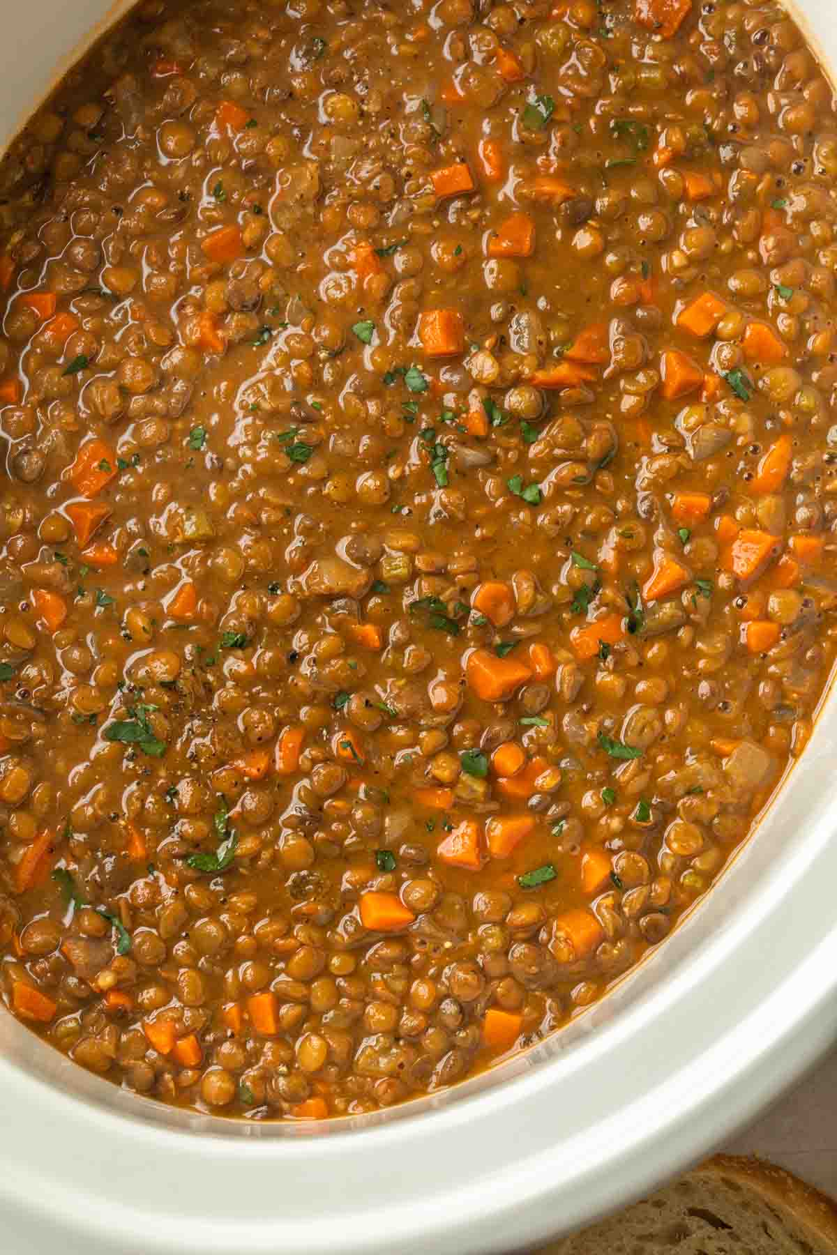 A slow cooker full of lentils and carrots. 