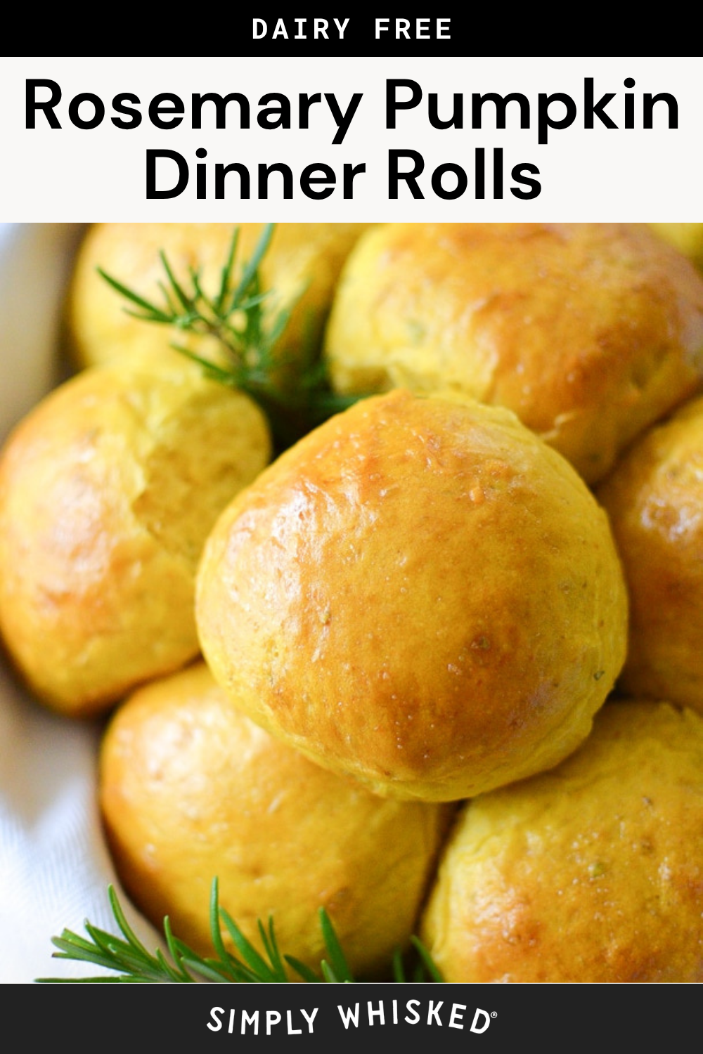 Golden brown pumpkin dinner rolls garnished with fresh rosemary are shown close up in a baking dish. The rolls are labeled as dairy free rosemary pumpkin dinner rolls.