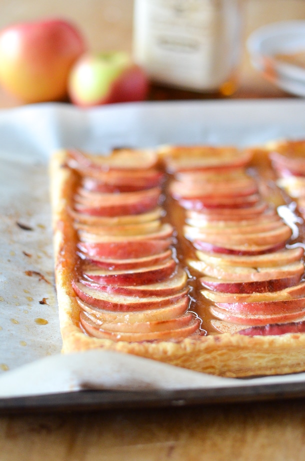 side view of glazed apples on puff pastry on a baking sheet