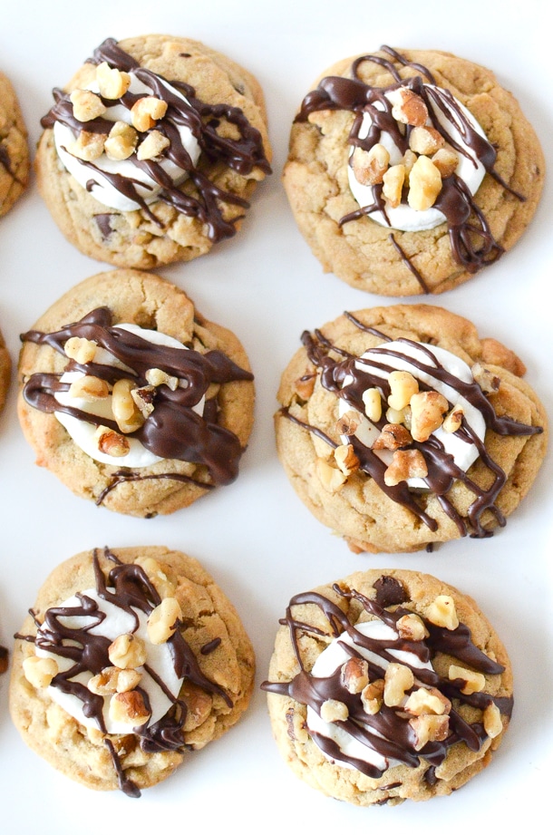 Overhead photo of cookies topped with marshmallow, nuts and chocolate. 