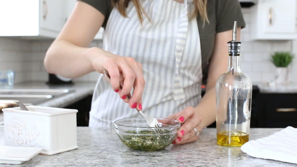 woman mixing herbs for a baked stuffed pork chops recipe