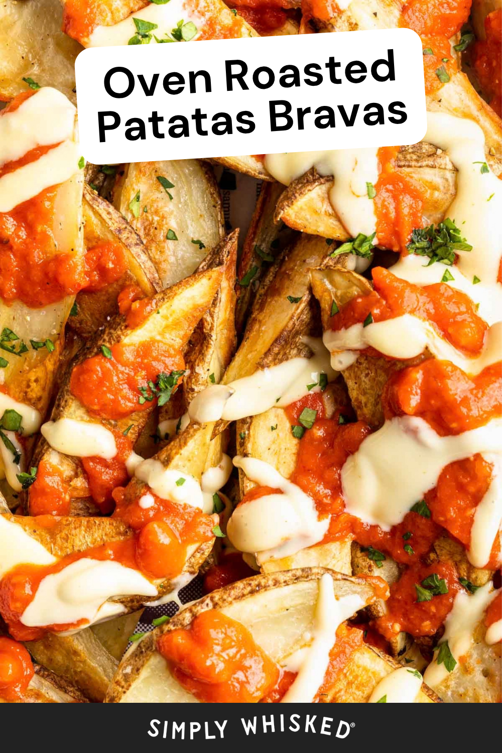 Golden potato wedges topped with classic patatas bravas red sauce and creamy white drizzle, garnished with chopped herbs. Text at the top reads Oven Roasted Patatas Bravas. Bottom text says Simply Whisked.
