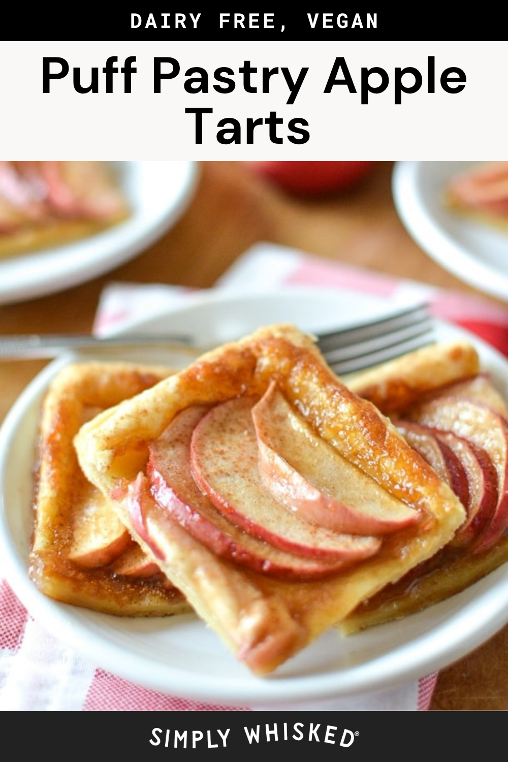 Two square puff pastry apple tarts with thin apple slices sit on a white plate with a fork. The image highlights the golden, flaky crust of these irresistible puff pastry apple tarts. Text at the top reads Dairy Free, Vegan Puff Pastry Apple Tarts.