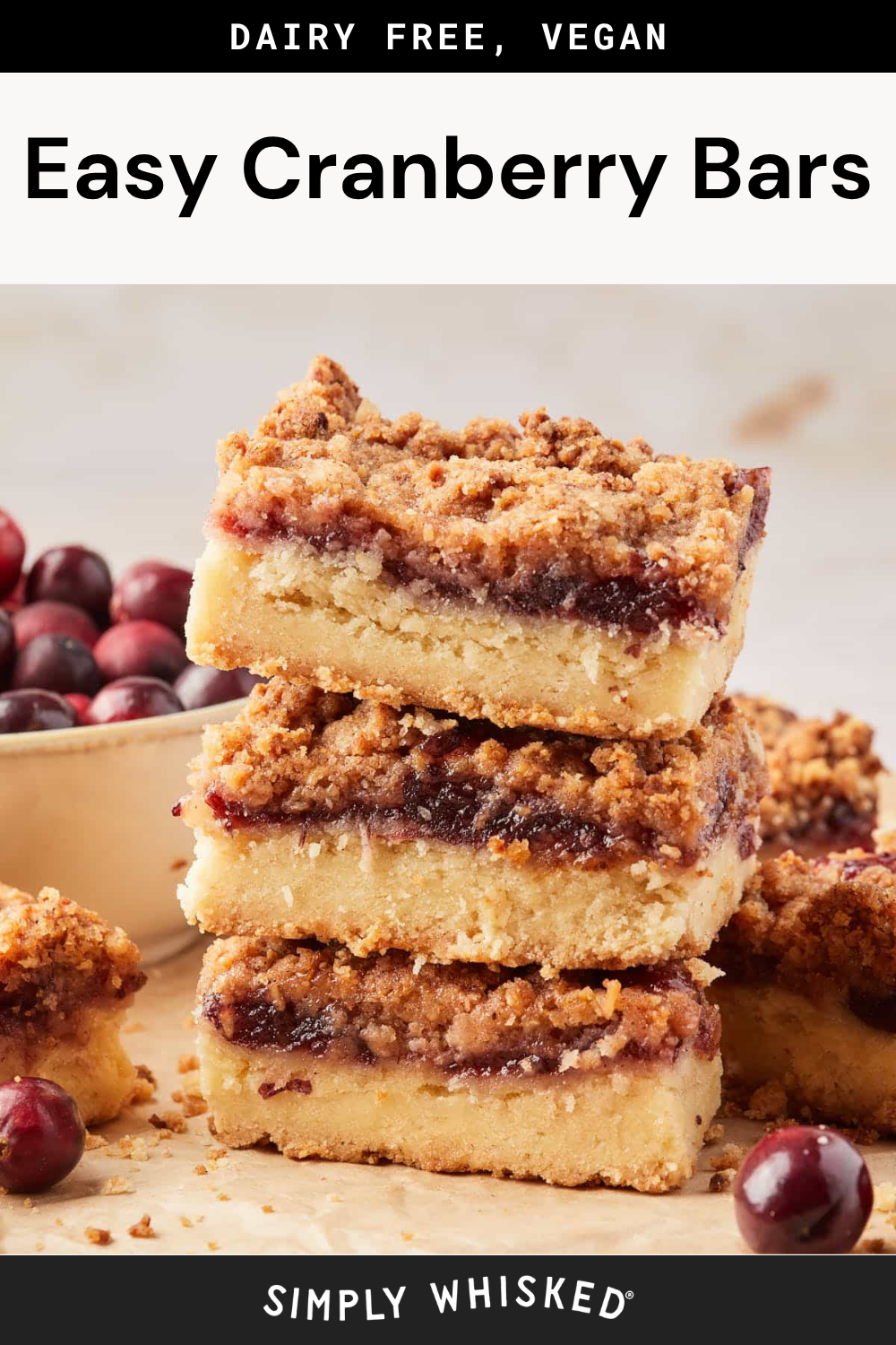 Three crumbly cranberry bars are stacked on a table next to fresh cranberries, with more cranberry bars displayed in the background. The text at the top reads Dairy Free, Vegan Easy Cranberry Bars.