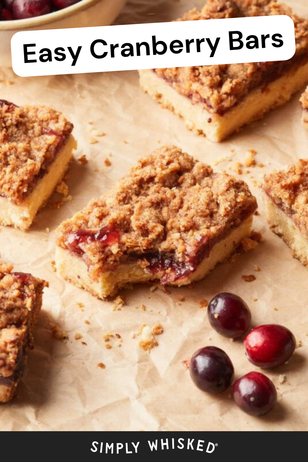 Cranberry crumb bars are arranged on parchment paper with fresh cranberries nearby. The top text reads Easy Cranberry Bars, and the bottom says Simply Whisked, perfectly highlighting these irresistible cranberry bars.