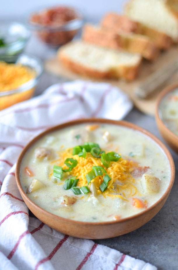 vegan potato soup topped with cheddar shreds and green onion