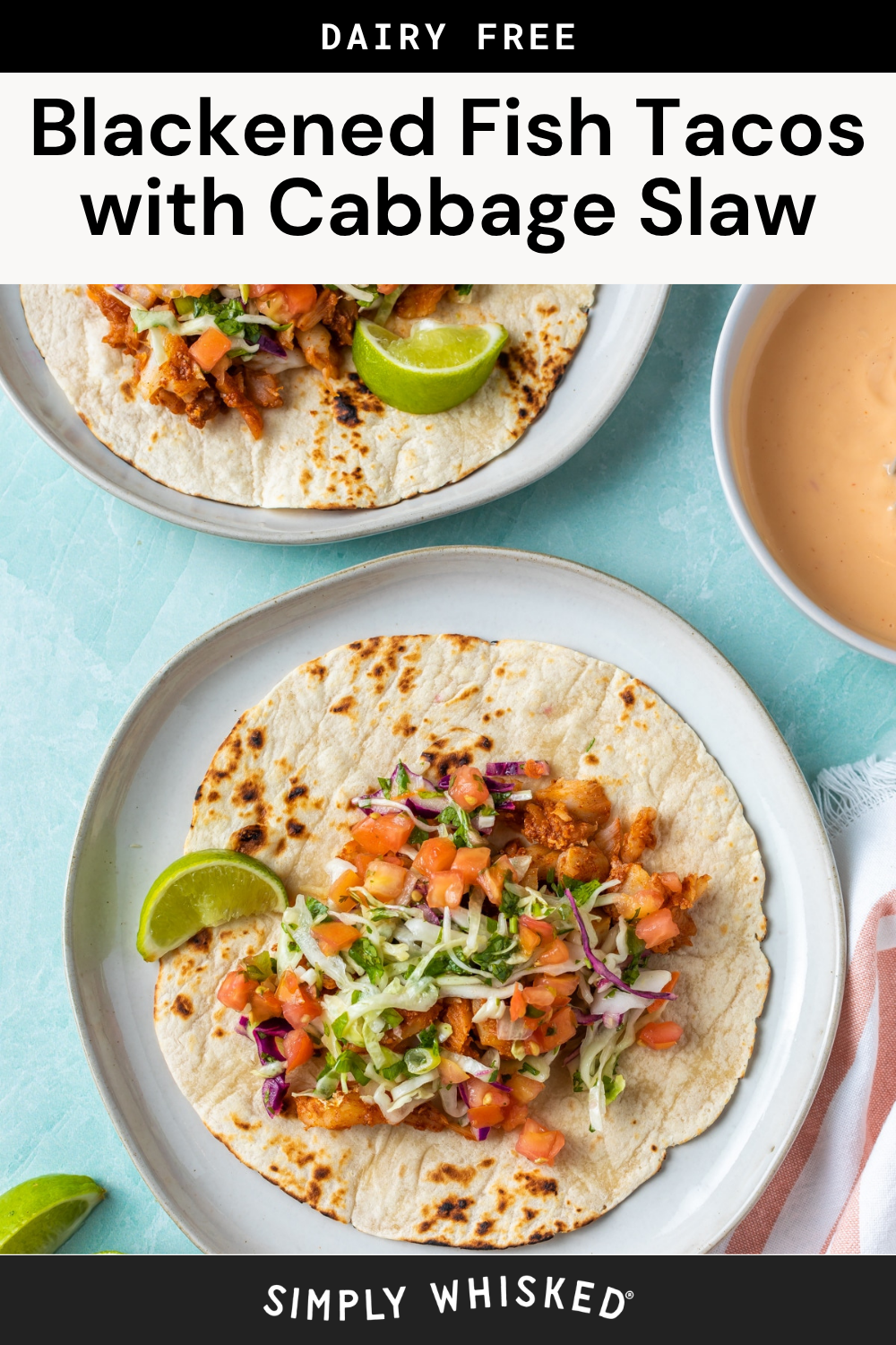 Two plates with blackened fish tacos topped with cabbage slaw and pico de gallo, served with lime wedges. A bowl of sauce sits nearby. The image advertises a delicious dairy-free recipe for blackened fish tacos with crisp cabbage slaw.