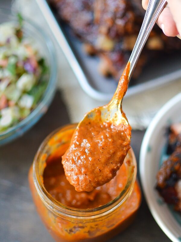 A jar of rhubarb bbq sauce being spooned out of the jar.