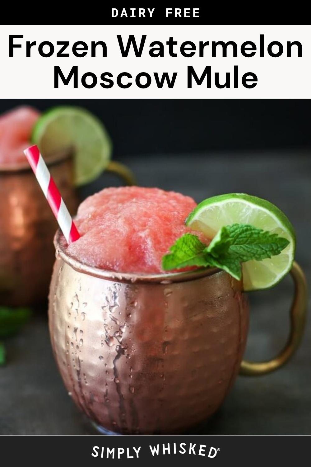 A copper mug filled with a frozen pink drink, garnished with a lime slice and mint sprig. A red and white striped straw is in the mug, hinting at the refreshing flavors of a frozen watermelon Moscow mule. Another similar mug appears blurred in the background.