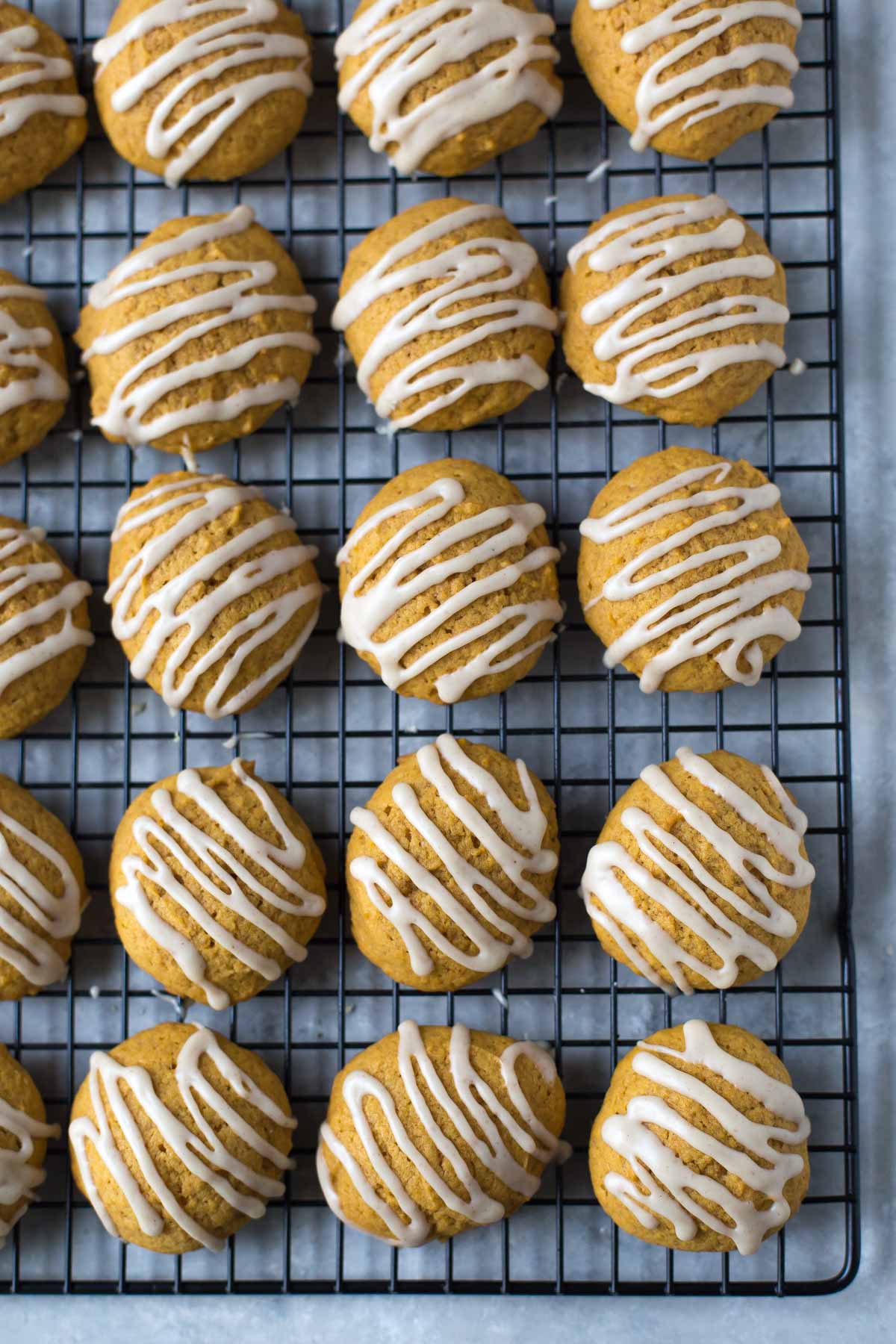 overhead view of soft pumpkin cookies with cinnamon drizzle on a cooling rack