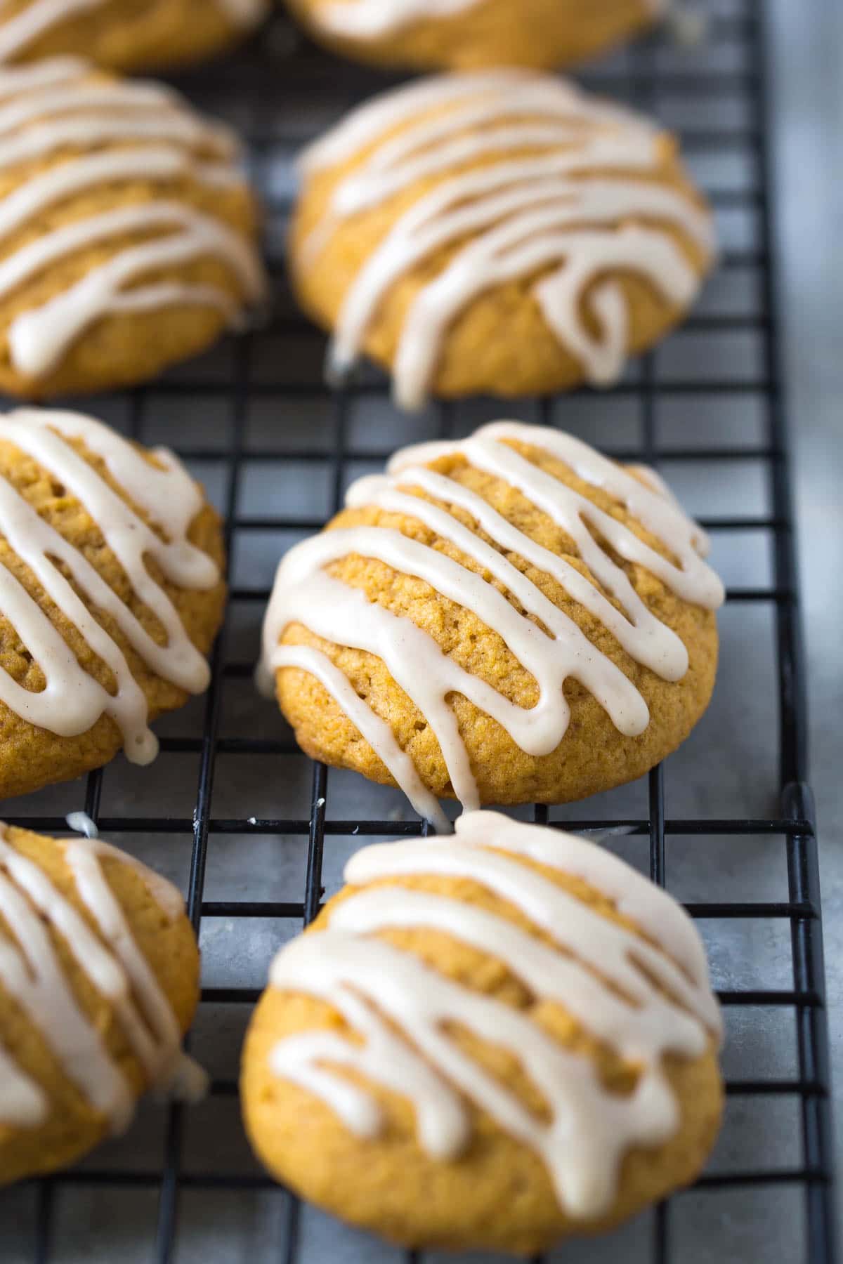 close up of pumpkin cookies on a cooling rack drizzled with cinnamon glaze