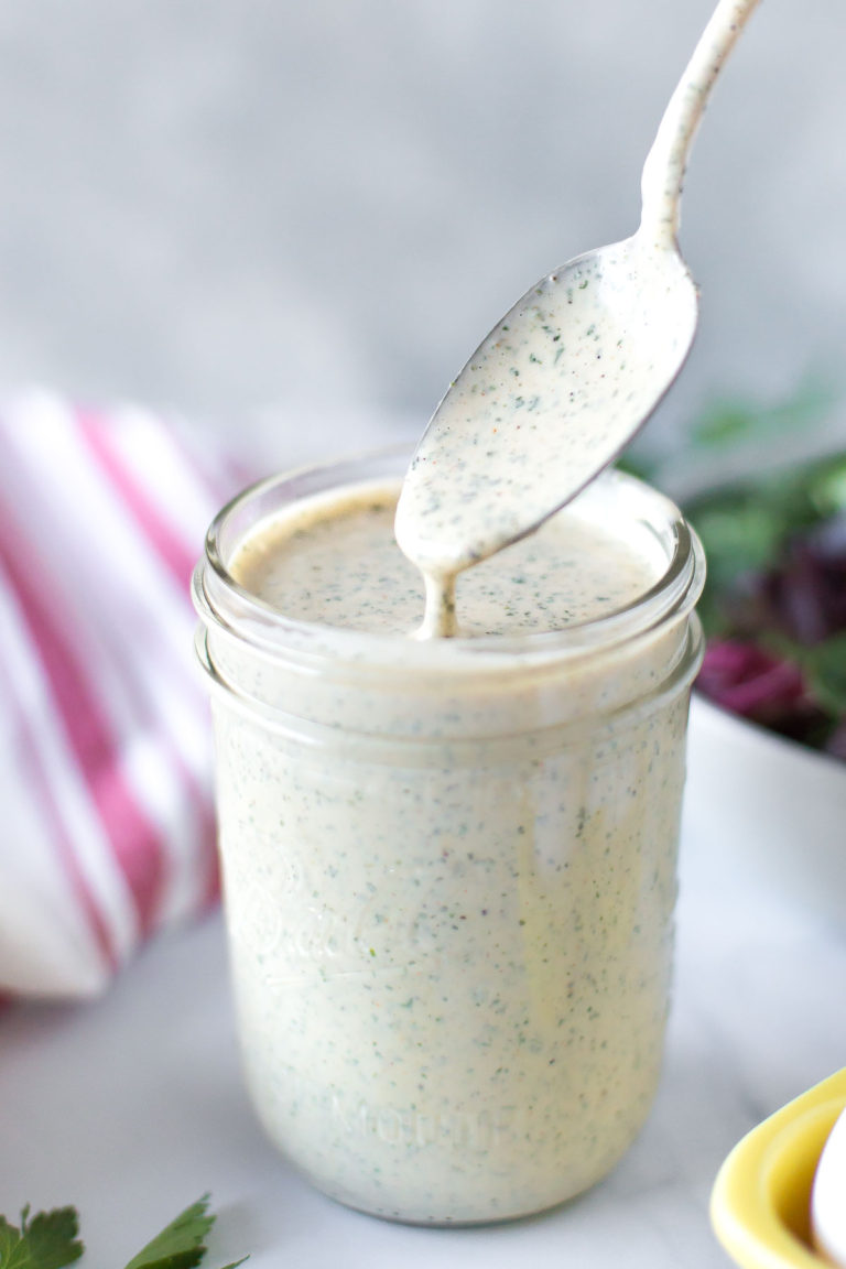 A jar of The BEST Dairy Free Ranch Dressing with a spoon coming out of it