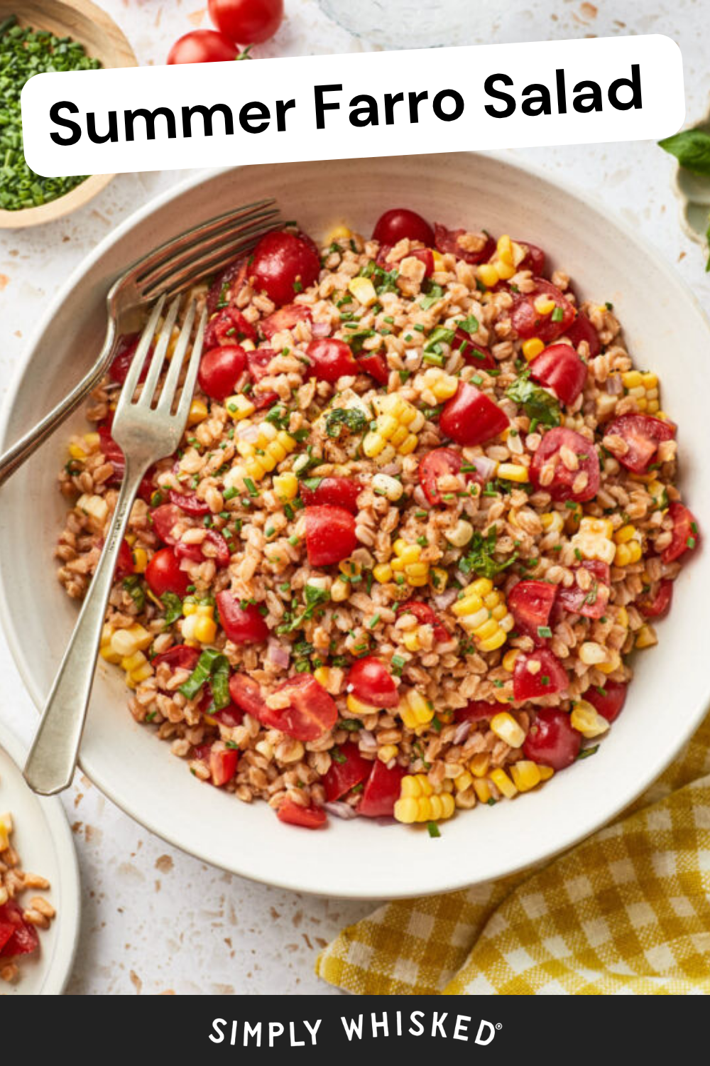 A bowl of vibrant summer farro salad with cherry tomatoes, corn, and herbs is served with two forks. A yellow checkered napkin rests beside chopped herbs and fresh tomatoes. Text reads: Summer Farro Salad and Simply Whisked.