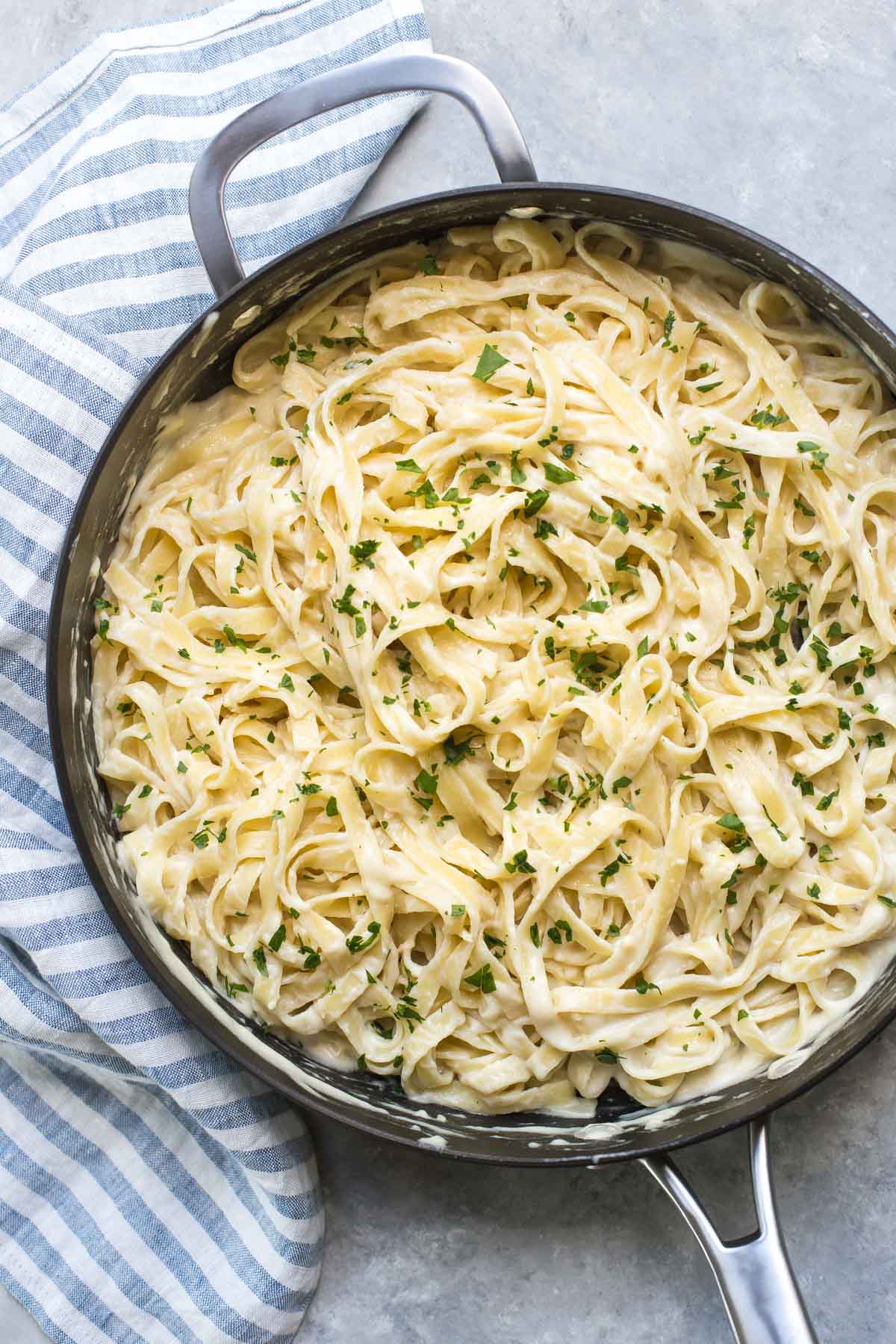 dairy free alfredo sauce on fettuccini in a large non-stick skillet topped with chopped parsley
