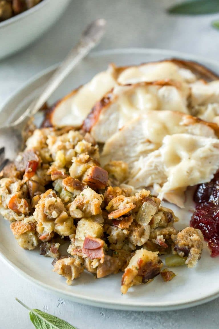 close up shot of pancetta chestnut stuffing on a plate with turkey, gravy and cranberry sauce