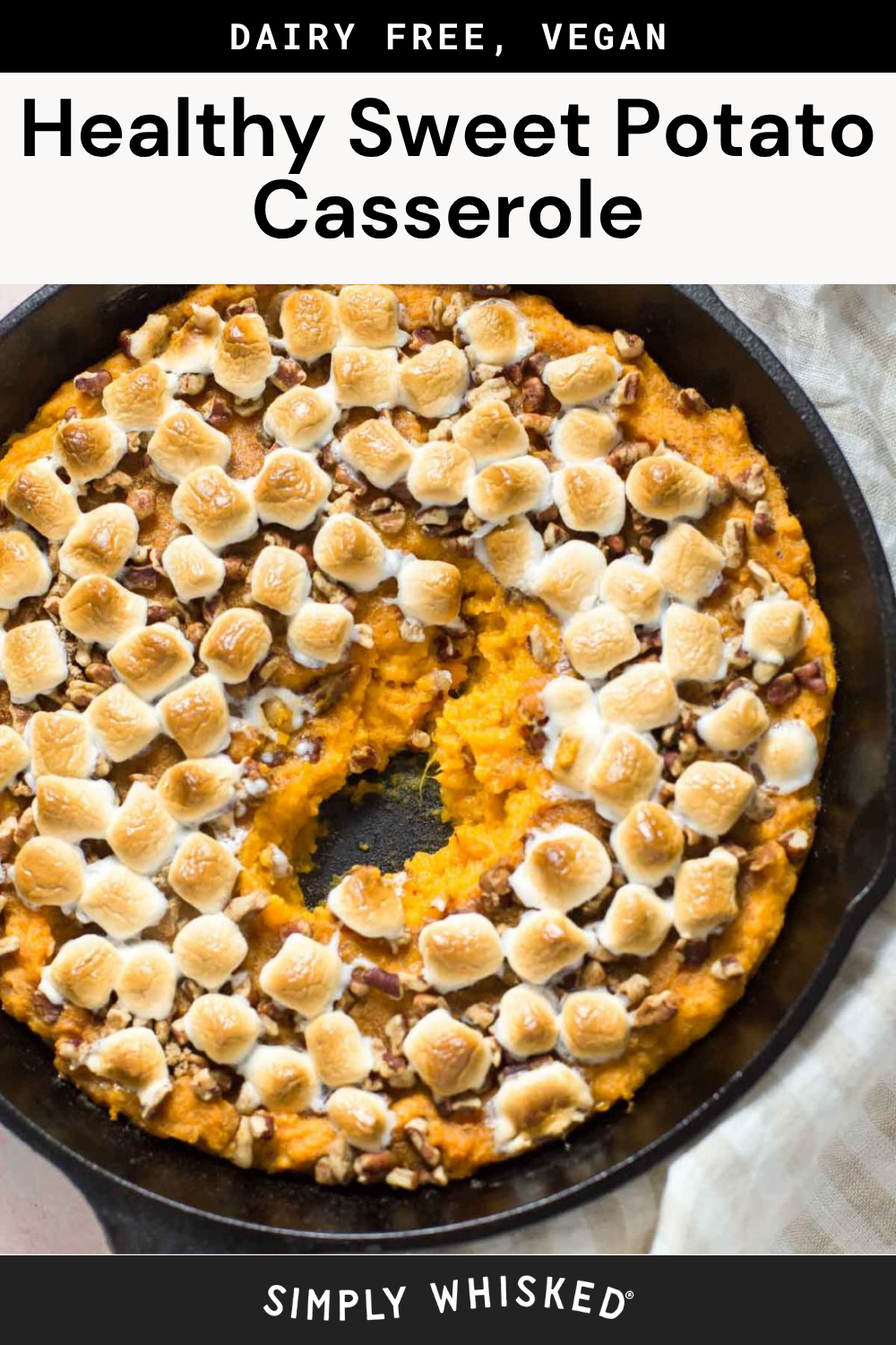 A skillet filled with healthy sweet potato casserole, topped with toasted marshmallows and pecans, with a serving scooped out. Text reads Healthy Sweet Potato Casserole—Dairy Free, Vegan.
