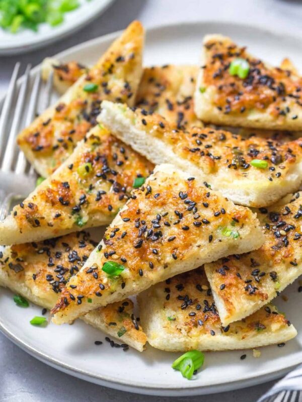 closeup of a plate with Chinese shrimp toast points topped with black sesame seeds