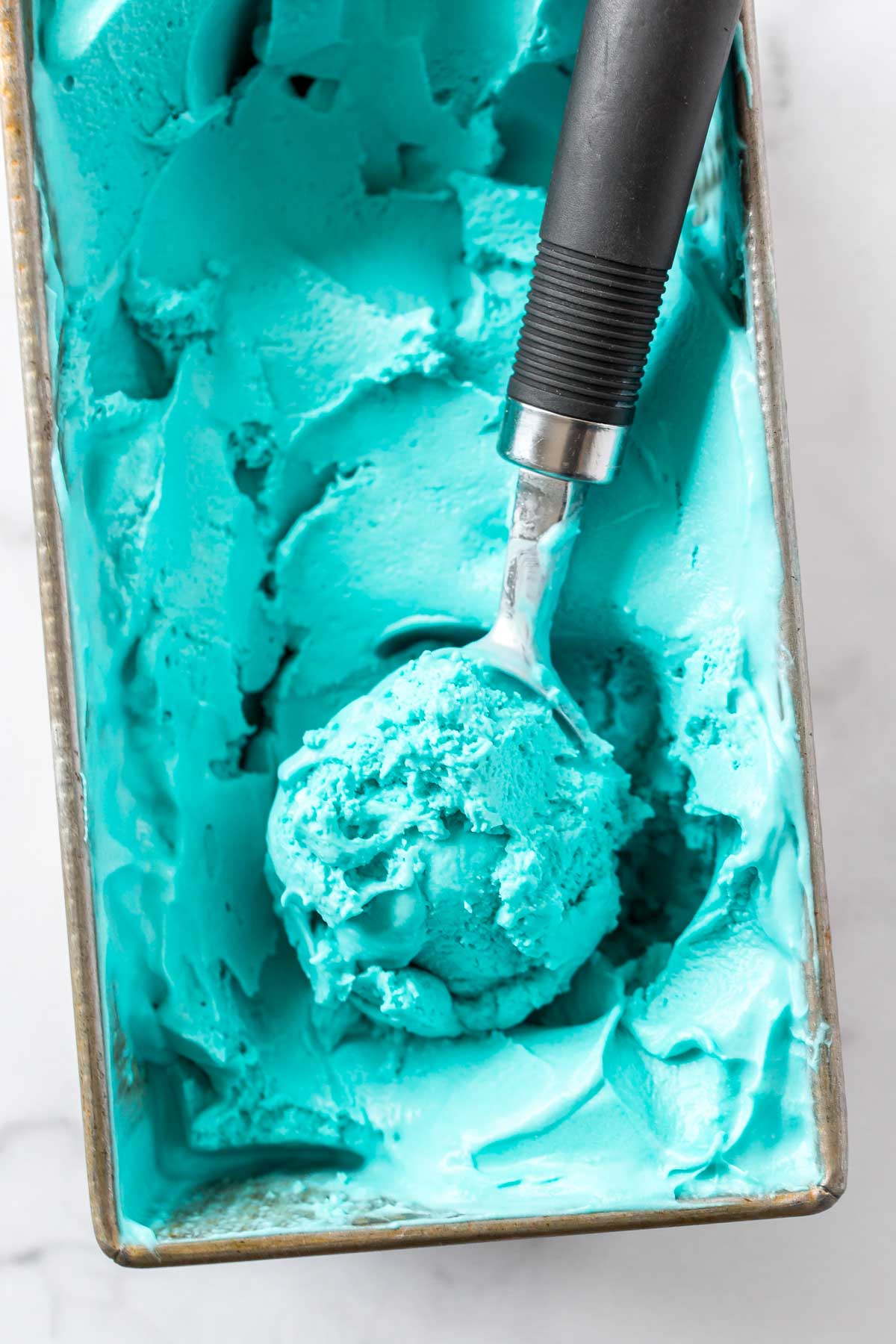 dairy free blue moon ice cream in a loaf pan with scoops take out