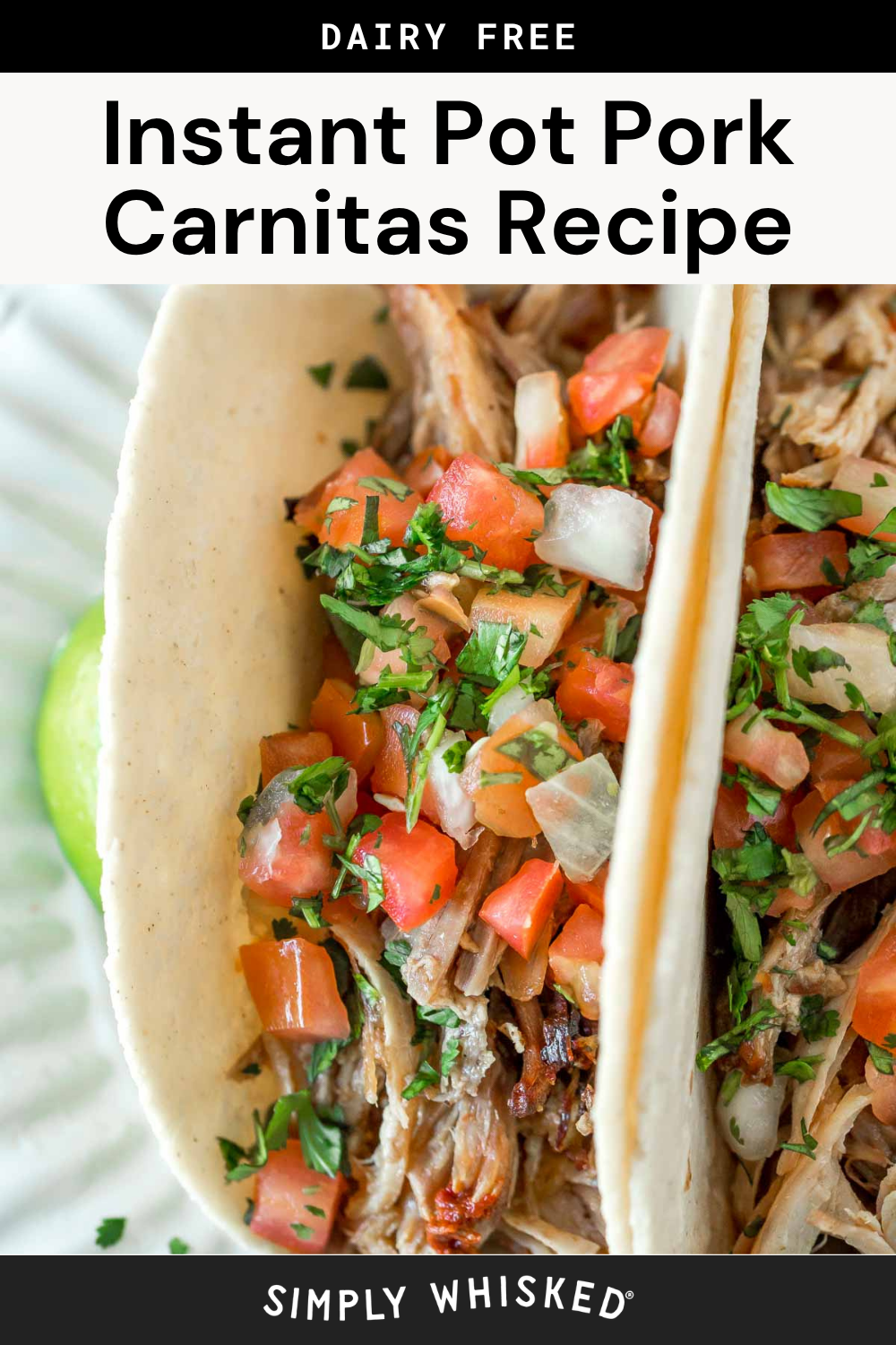 Close-up of two Instant Pot pork carnitas tacos topped with diced tomatoes, onions, and cilantro on a tortilla. A lime wedge is partially visible on a white plate underneath. Text above and below describes the recipe and blog source.
