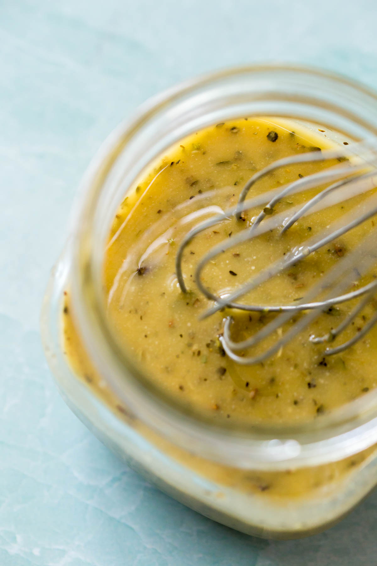 homemade Italian pasta salad dressing in a mason jar with a whisk