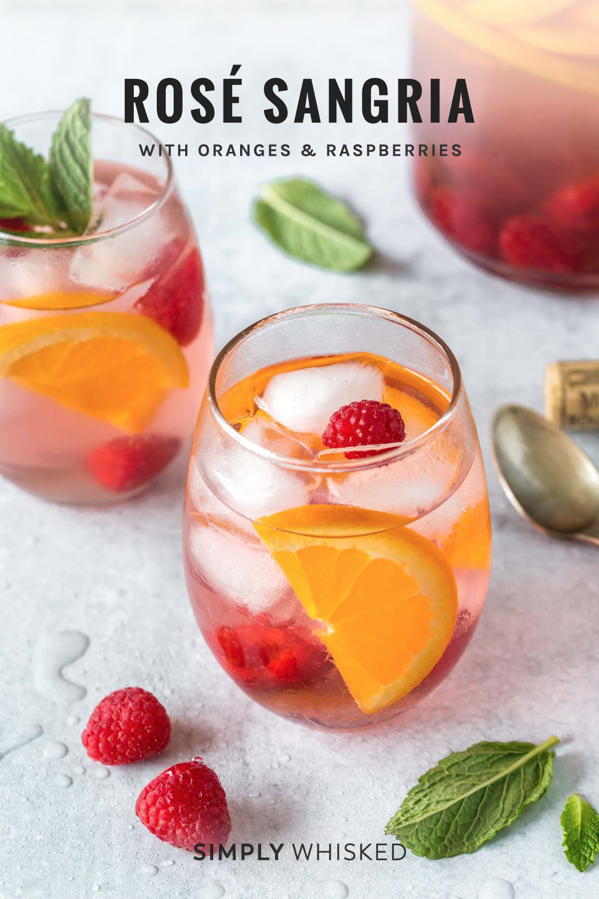 rose sangria recipe garnished with orange slices, raspberries and mint leaves