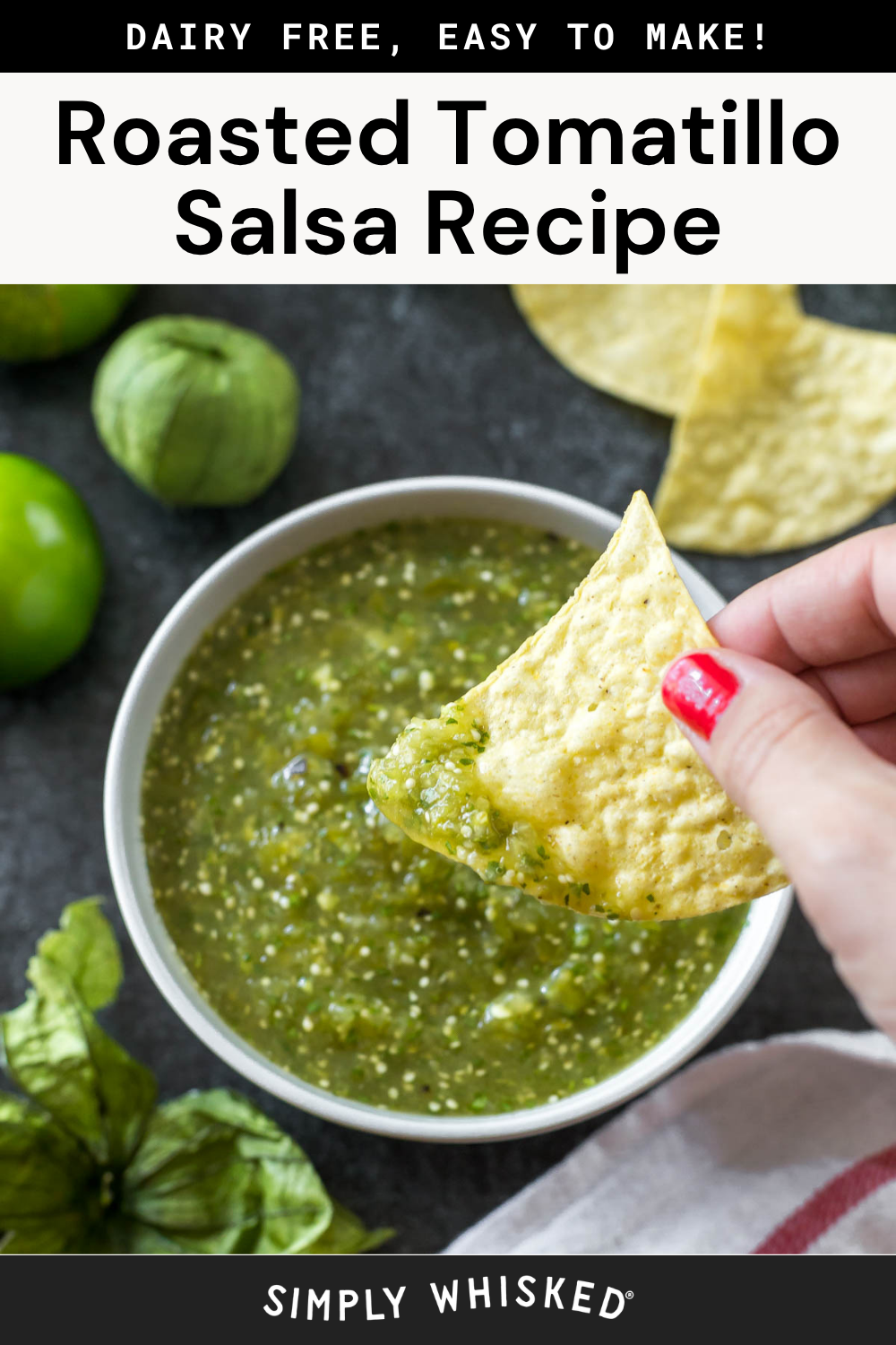 A hand dips a tortilla chip into a bowl of vibrant roasted tomatillo salsa. Fresh tomatillos and a lime are nearby. Text above reads Roasted Tomatillo Salsa Recipe and Dairy Free, Easy to Make!.