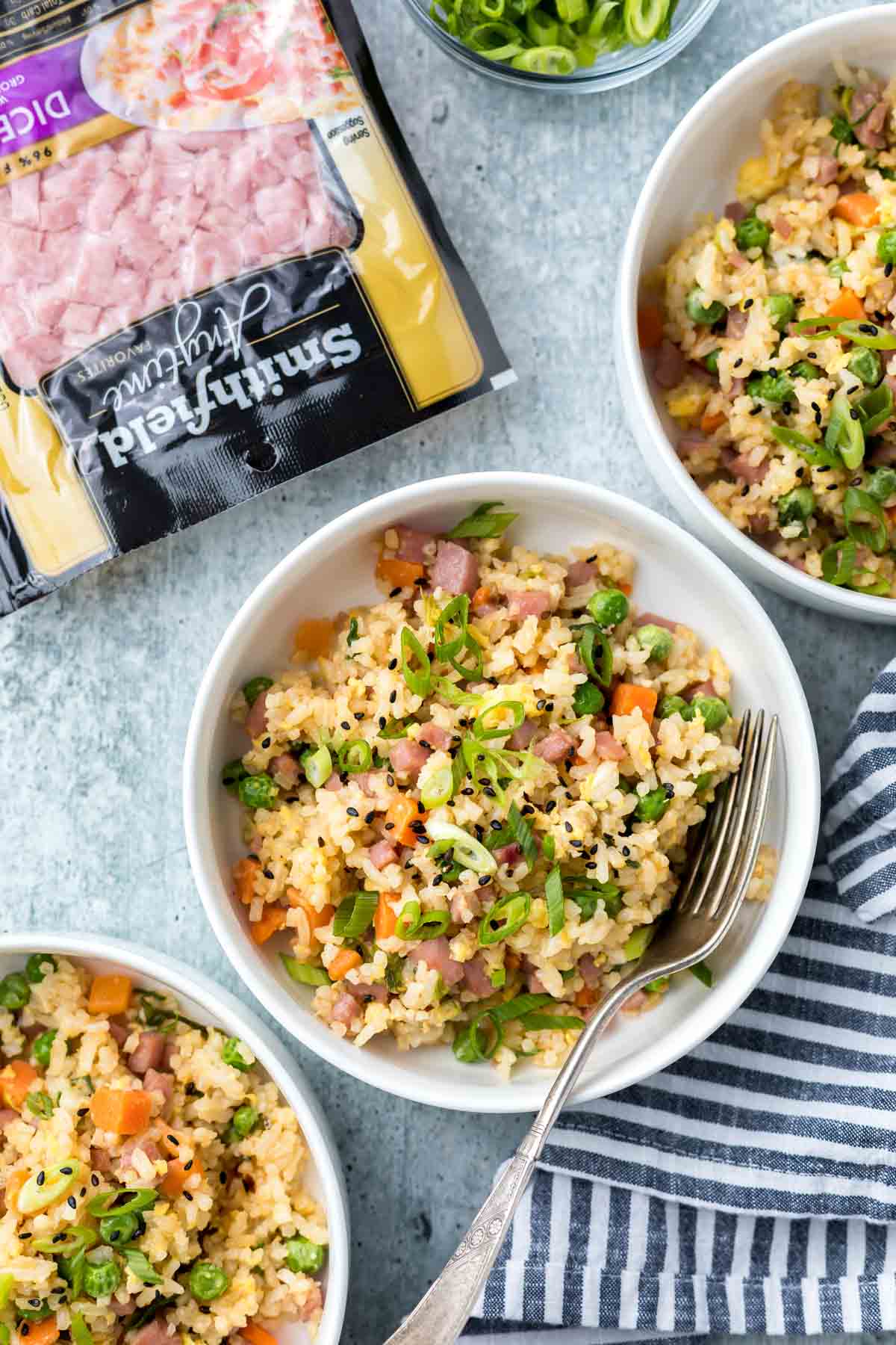 three bowls of ham fried rice with a package of smithfield diced ham in the background