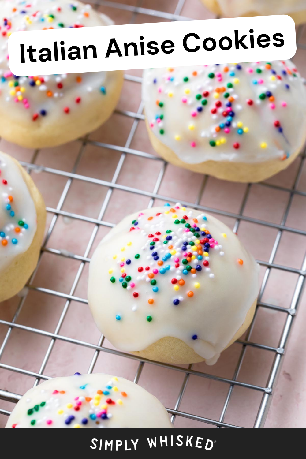 Round cookies with white icing and colorful sprinkles sit on a cooling rack. A label reads Italian Anise Cookies at the top, with SIMPLY WHISKED at the bottom, capturing the classic appeal of homemade anisette cookies.