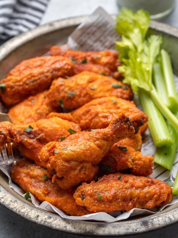 side view of chicken wings and celery on a plate