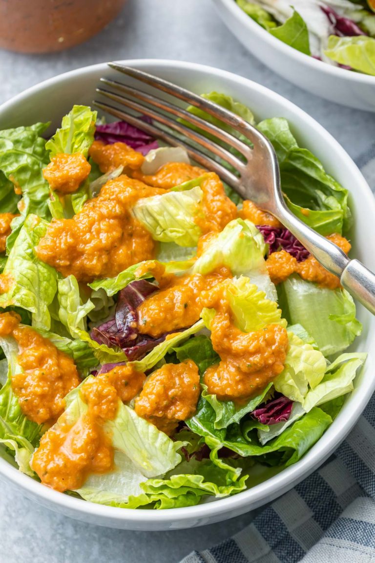 a close up view of a salad with ginger dressing on it and a fork