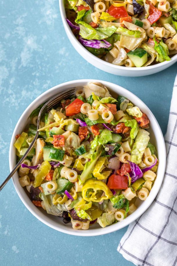 An aerial view of chopped Italian salad with a towel and bowl to the side