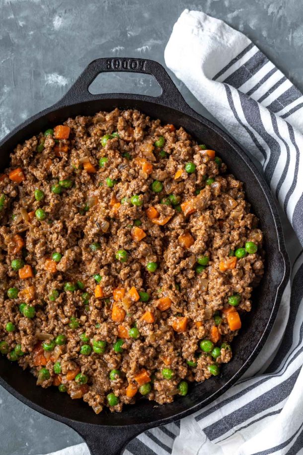 a cast iron filled with the meat mixture for shepherds pie