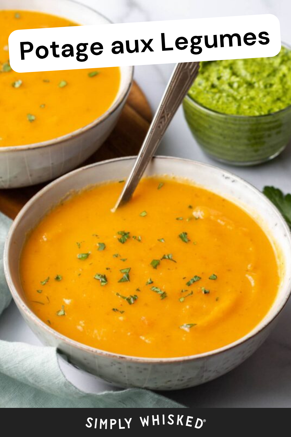 Two bowls of creamy orange vegetable soup with chopped herbs on top, a spoon in one bowl, and a small bowl of green sauce nearby. The text reads Potage aux Legumes..