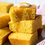 a stack of honey covered cornbread with a slice of butter on top