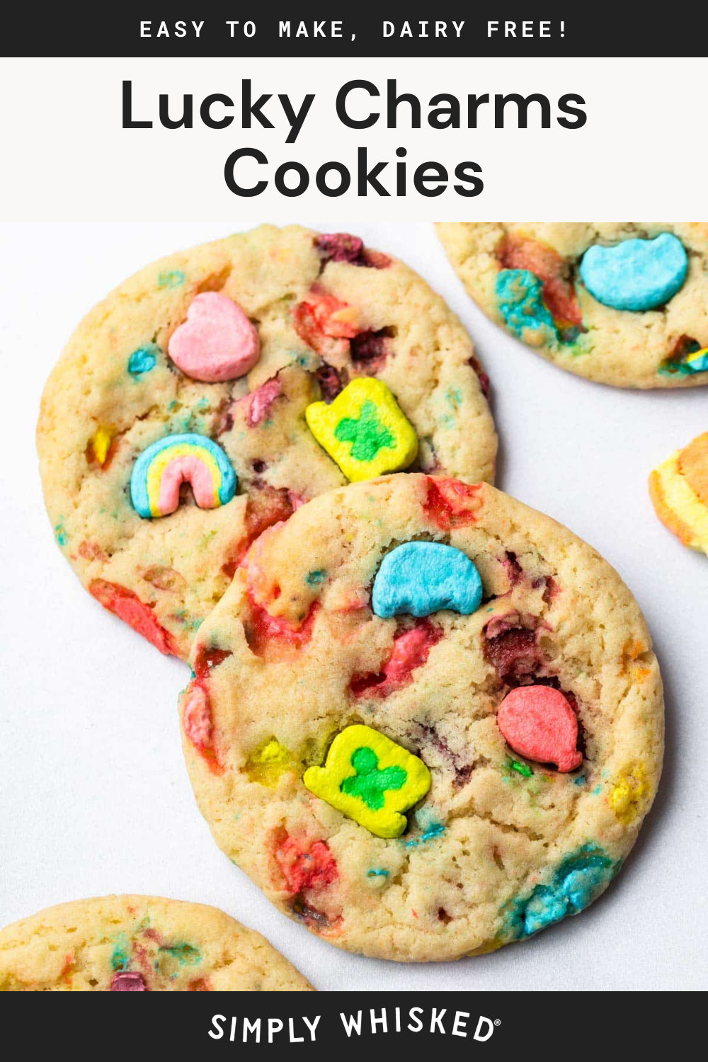 Three Lucky Charms cookies filled with colorful marshmallows are displayed on a white surface. These soft, chewy treats are packed with vibrant marshmallow pieces throughout. Text above reads Lucky Charms Cookies.