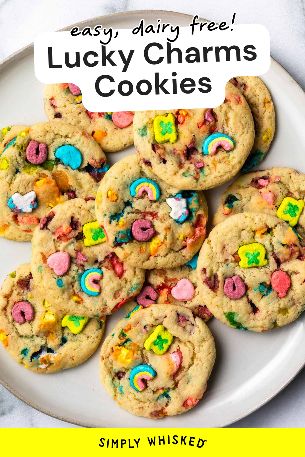 A plate of colorful Lucky Charms cookies topped with marshmallows, labeled “easy, dairy free! Lucky Charms Cookies” at the top and “Simply Whisked” at the bottom.