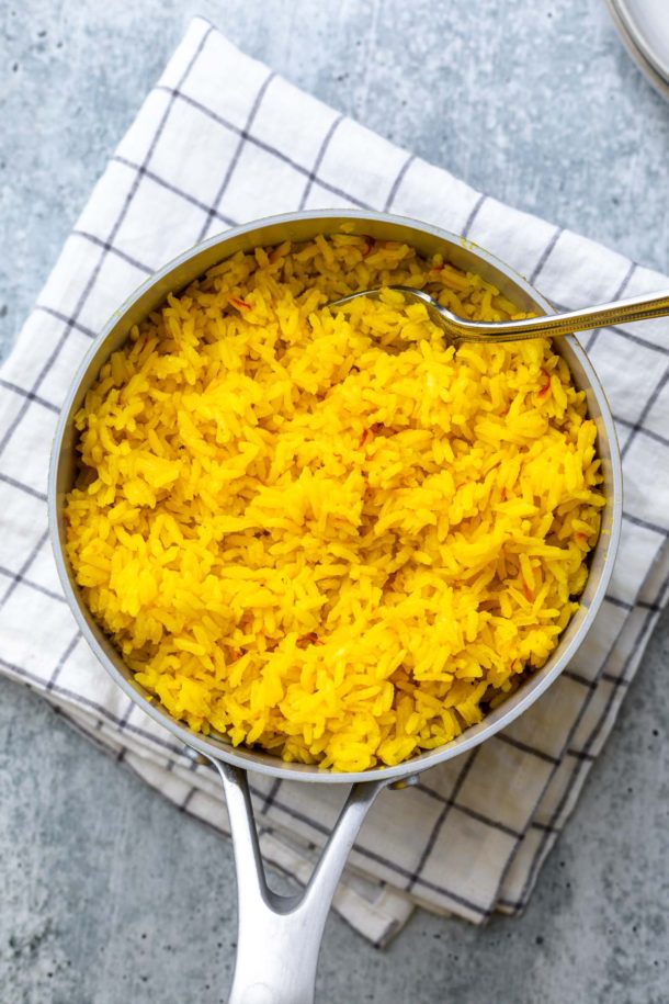 fluffed saffron rice in a pot with a fork