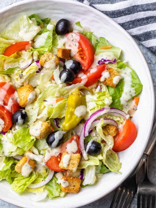 A close up view of the salad dressing drizzled over the olive garden salad